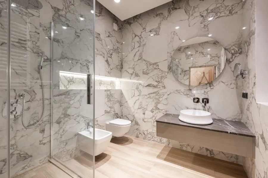 Remodeled marble bathroom with vessel sink faucet and glass shower gear
