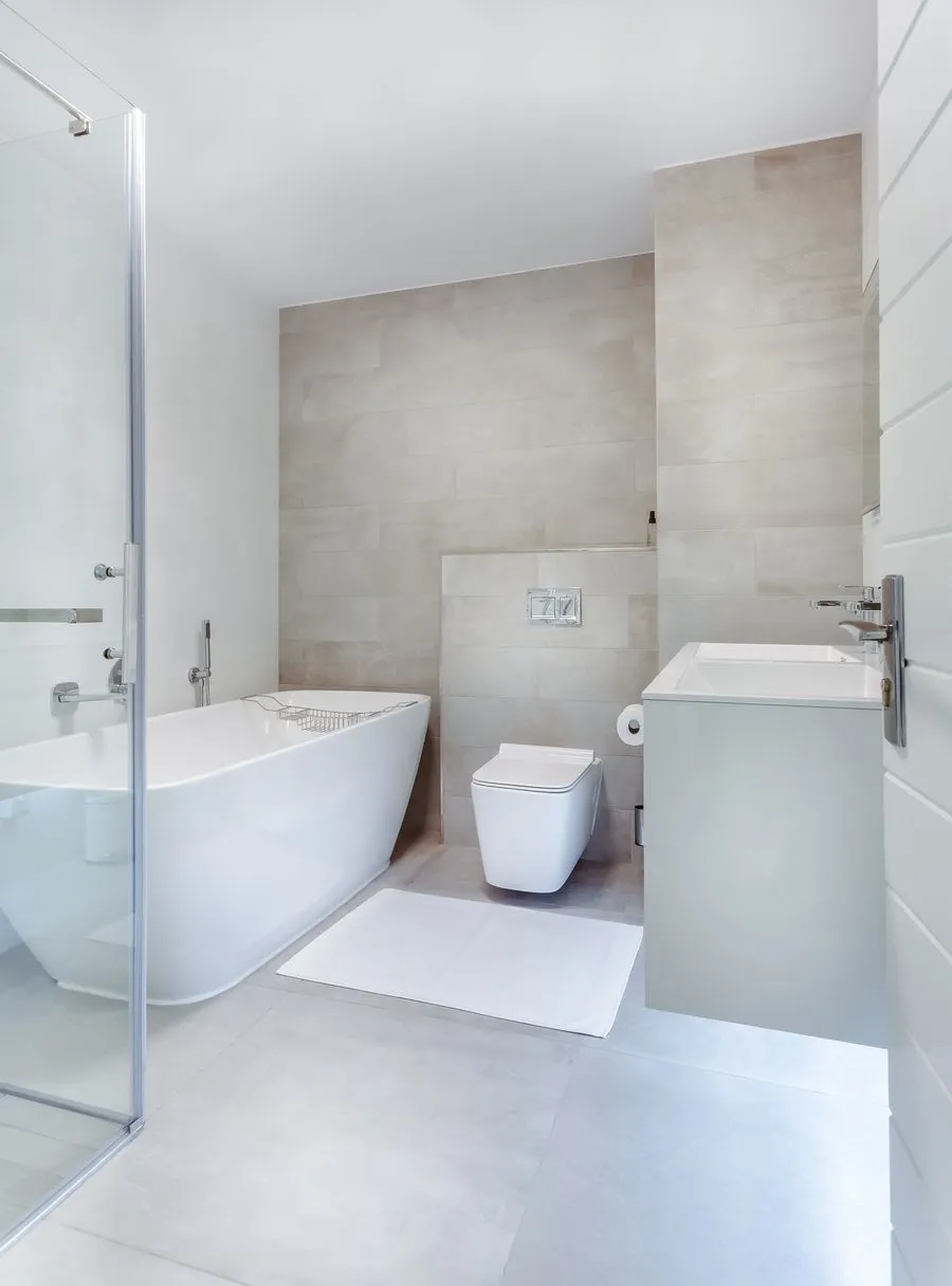 Clean residential bathroom with wall-mounted toilet for home service