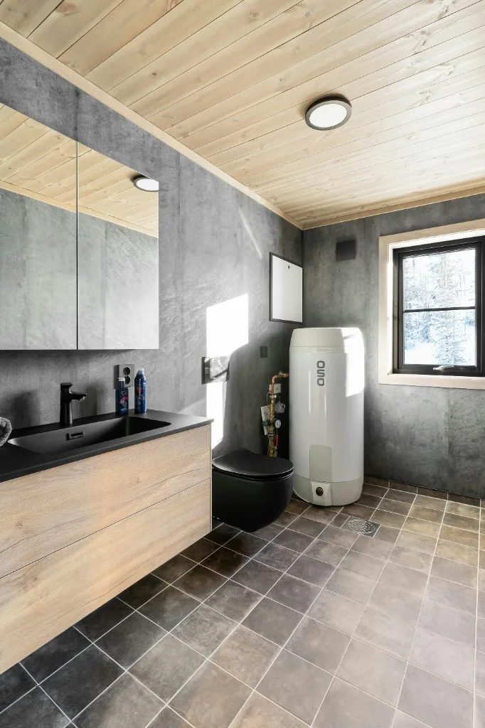Modern electric water heater tank professionally installed in a residential bathroom